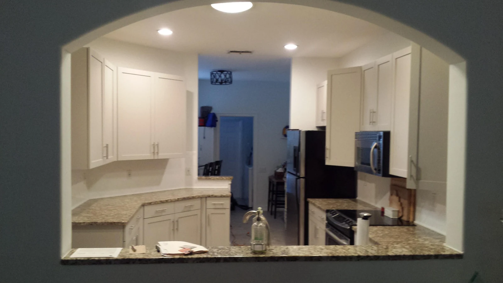 The same cabinets seen through the arched opening with updated fronts