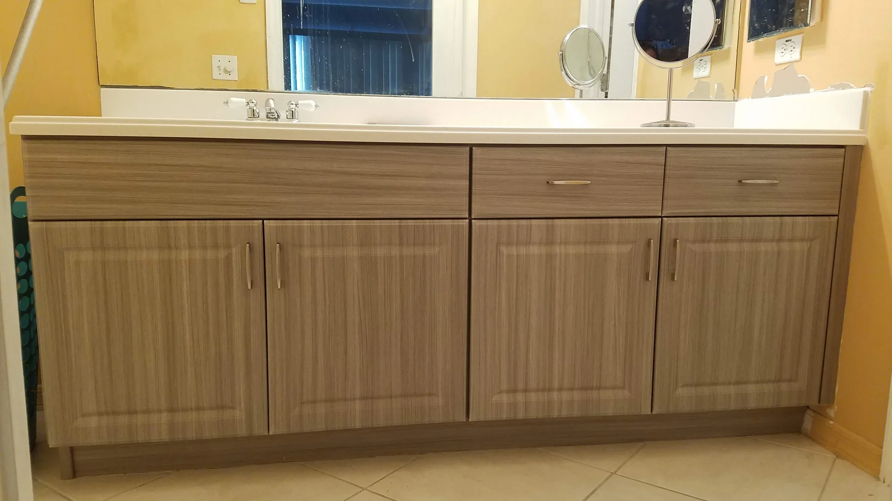 Woodgrain bathroom vanity with coordinated drawer fronts, cabinet doors and brushed pulls