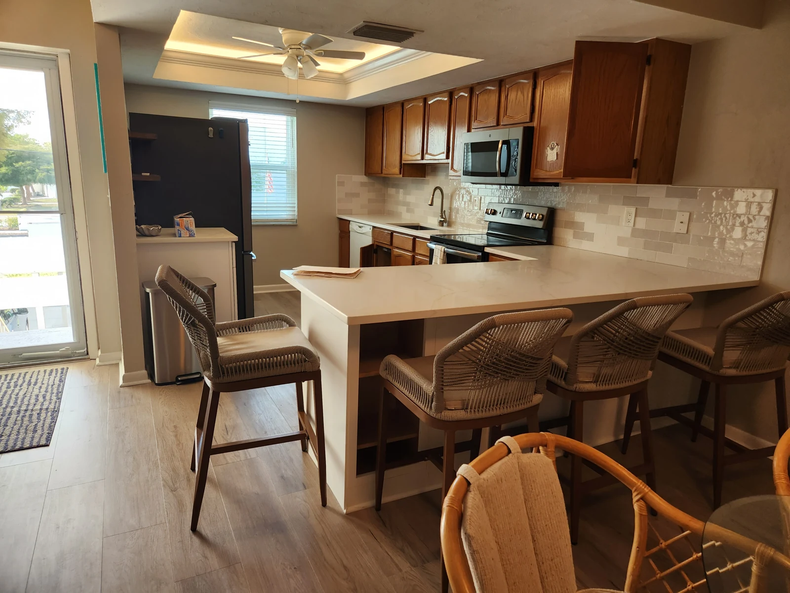 Kitchen before refacing, with raised-panel oak cabinet doors and dark hardware